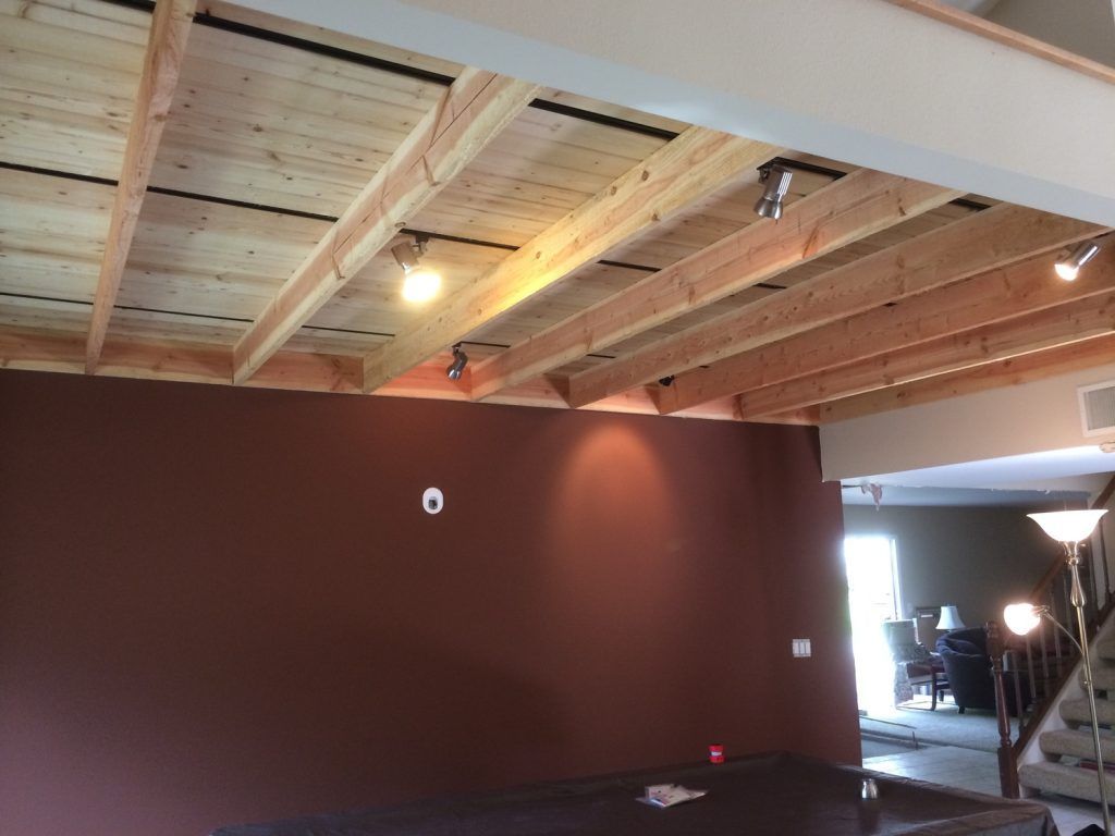 A living room with a wooden ceiling and brown walls