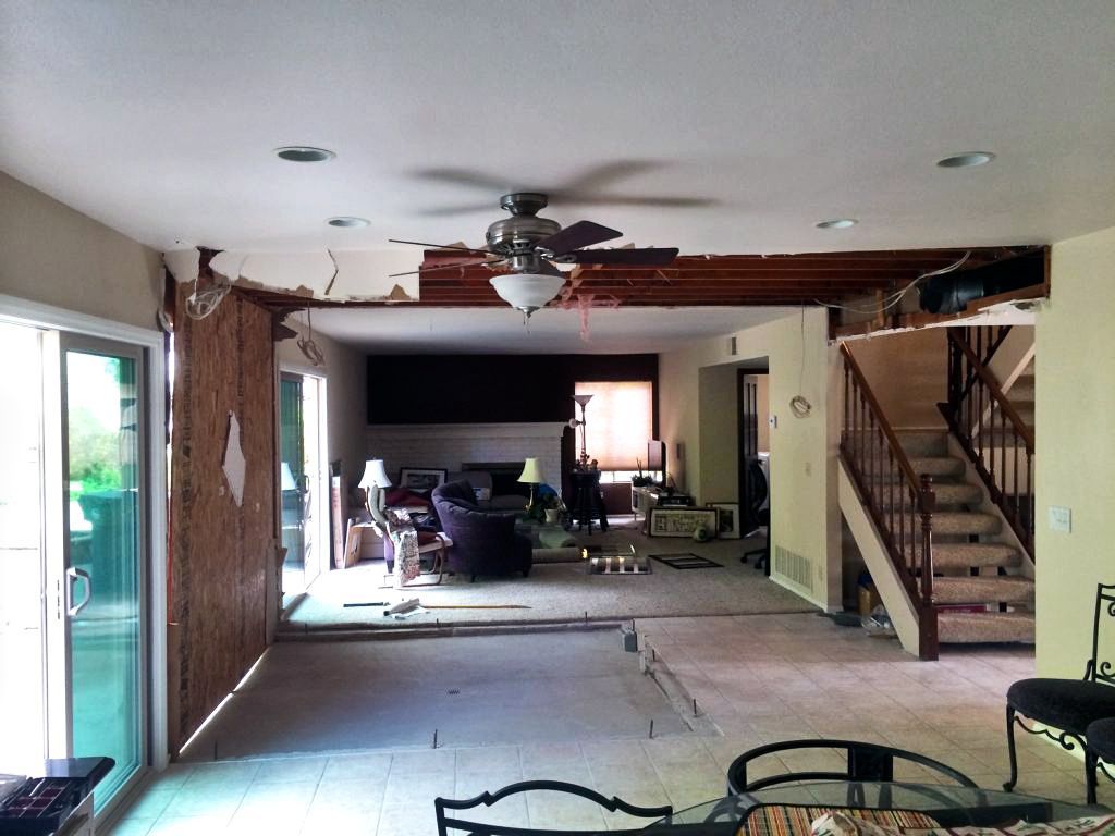A living room with a ceiling fan and stairs