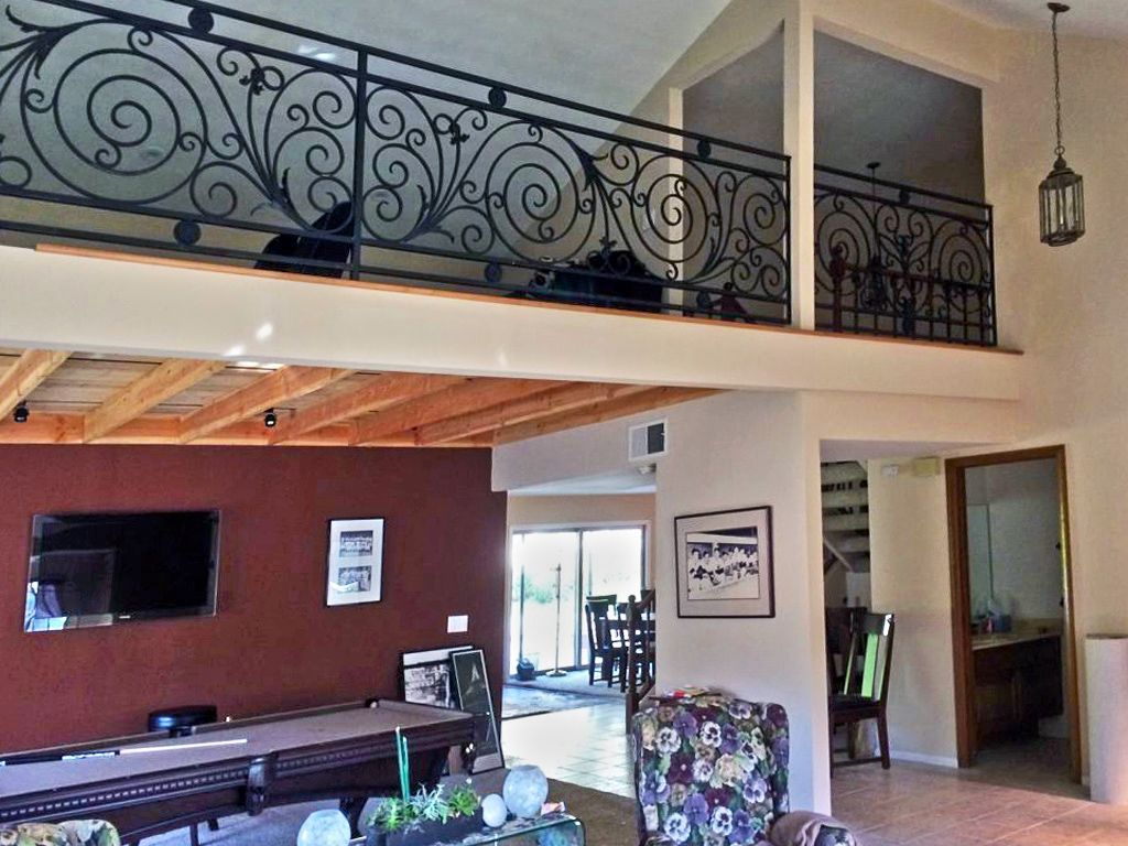 A living room with a pool table and a balcony