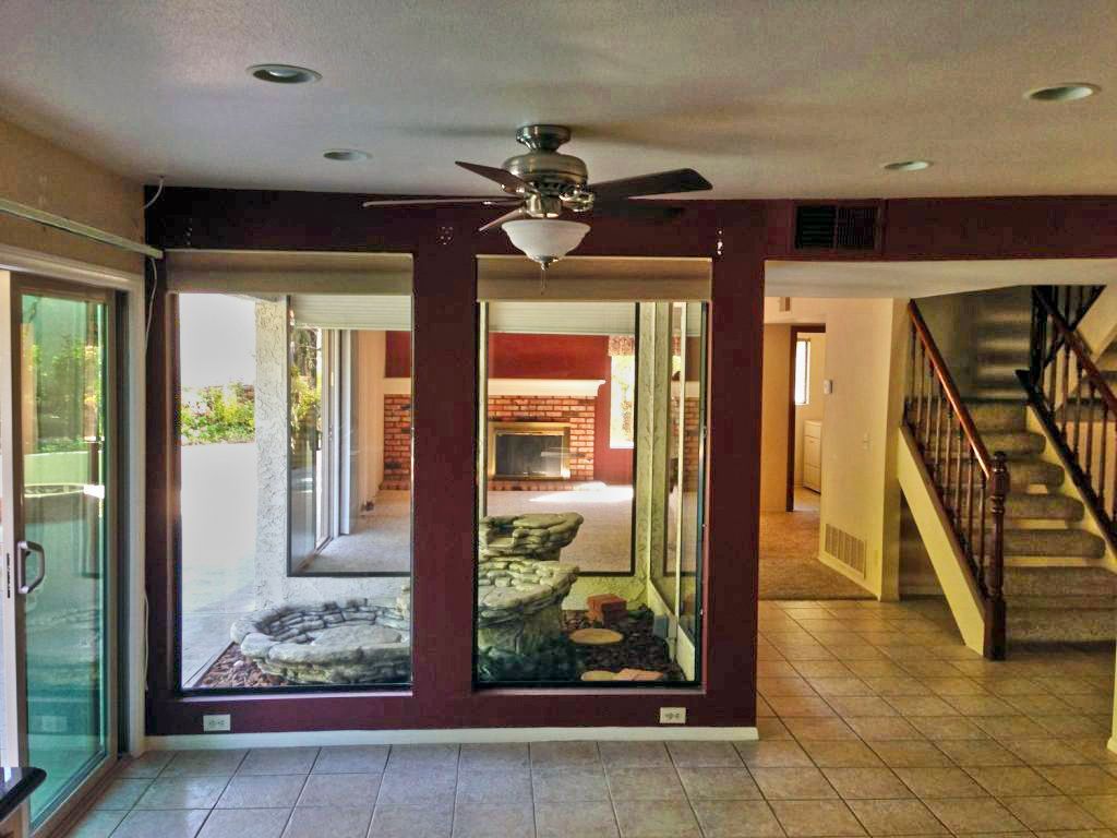 A living room with a ceiling fan and stairs
