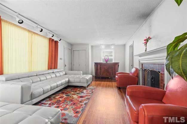 A living room with a couch , chairs , and a fireplace.