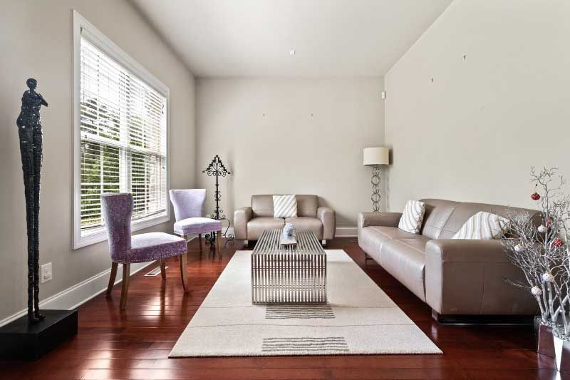 A living room with a couch , chairs , and a coffee table.