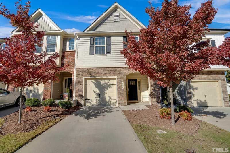 The front of a house with a car parked in front of it.
