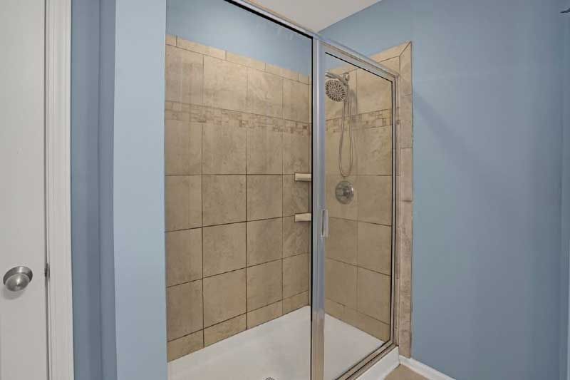 A bathroom with a walk in shower and a tub.