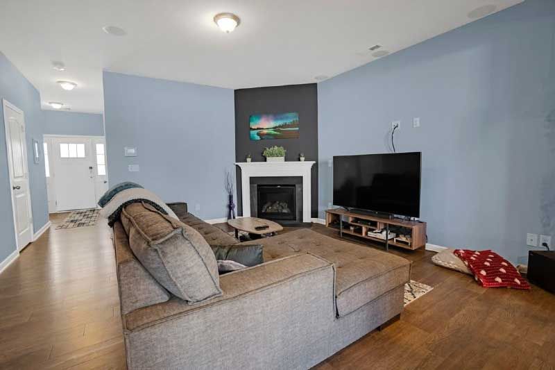 A living room with a couch , fireplace and television.