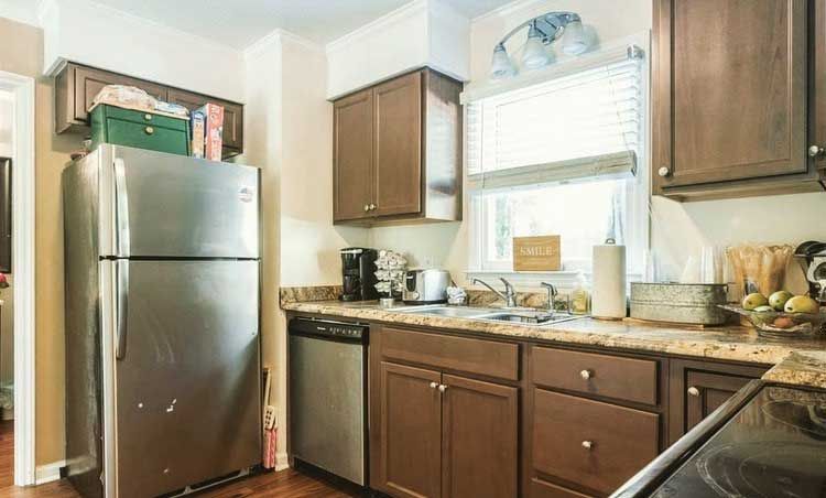 A kitchen with stainless steel appliances and wooden cabinets.
