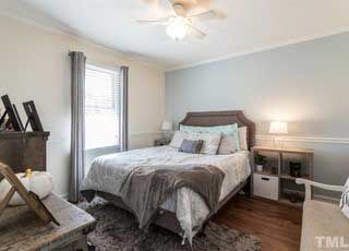 A bedroom with a bed and a ceiling fan.