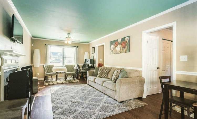 A living room with a couch , table , chairs and television.