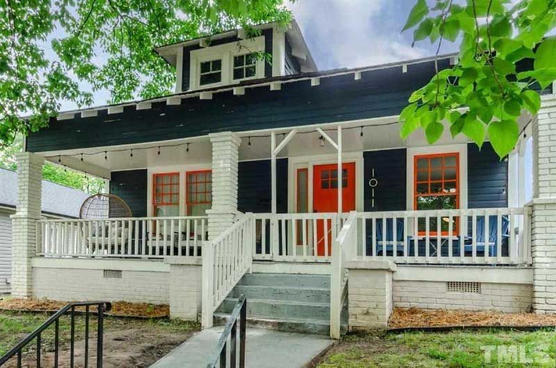A blue and white house with a porch and stairs