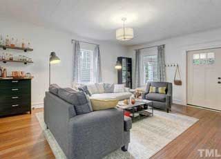 A living room with a couch , chairs , and a coffee table.