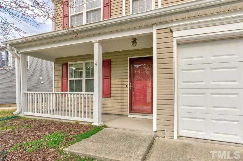 The front of a house with a porch and a garage door.