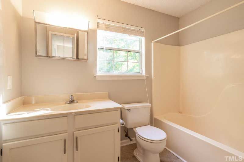 A bathroom with a toilet , sink , and bathtub.