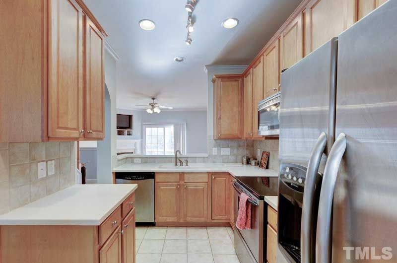 A kitchen with stainless steel appliances and wooden cabinets.
