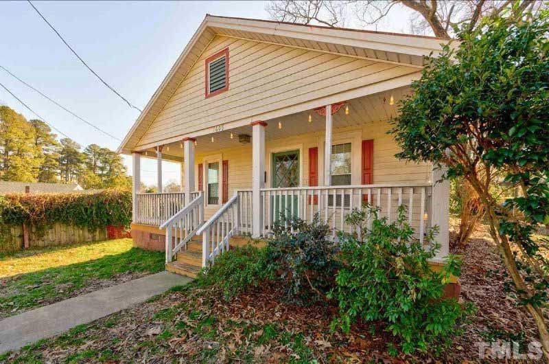 A house with a porch and stairs is for sale.