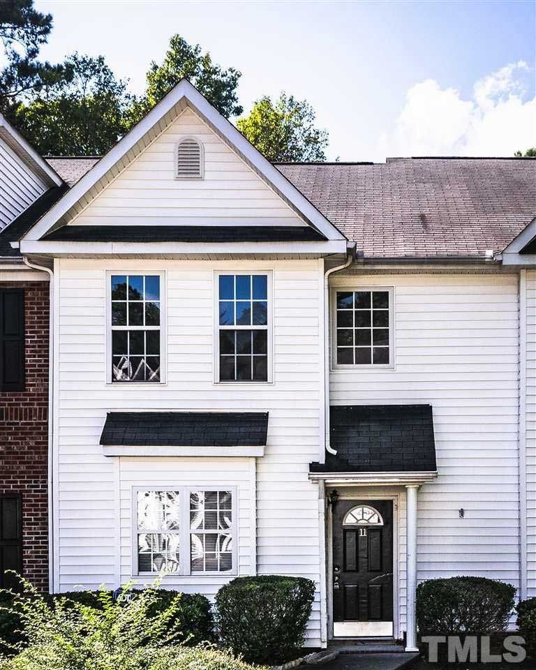 A white house with a black door is for sale by tmls