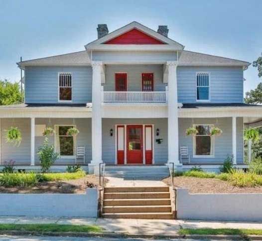 A large house with a red door and stairs
