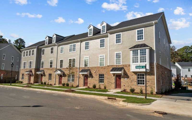 A row of apartment buildings sitting next to each other on a sunny day.