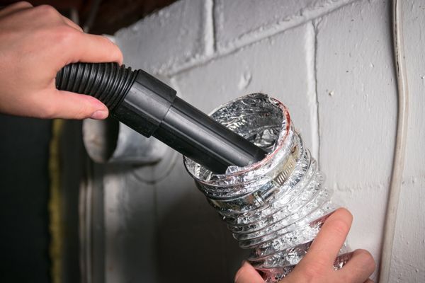 a person is using a vacuum cleaner to clean a duct