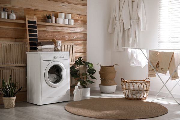 a laundry room with a washing machine and drying rack