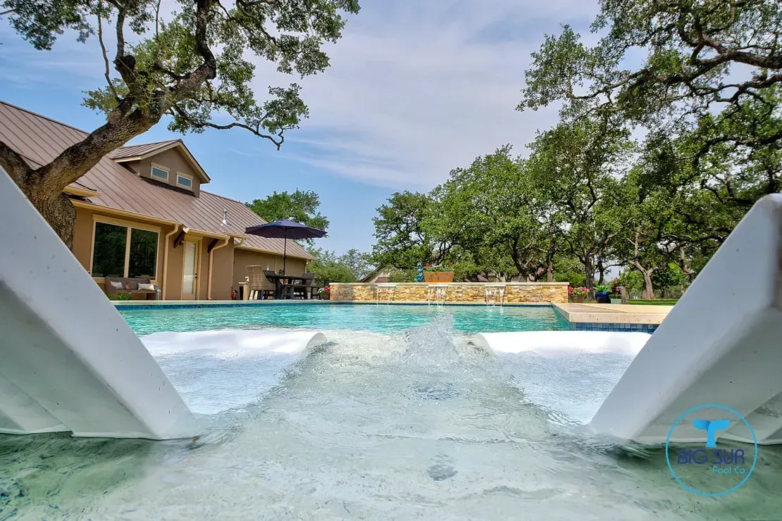 Swimming pool with clear water and a tropical resort building in the background