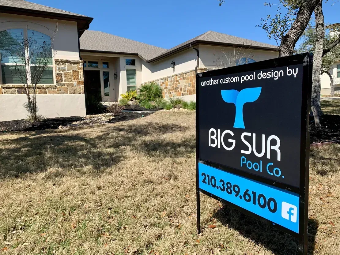 Real estate sign in front of a house reading “Big Sur Pool Co.” with phone number 210-389-6100