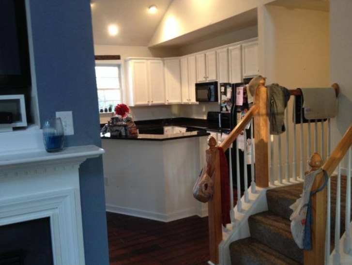 A kitchen with a fireplace and stairs leading up to it