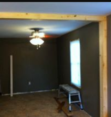 An empty room with a ceiling fan and a window.