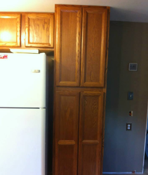 A kitchen with a white refrigerator and wooden cabinets