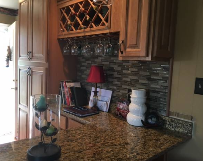 A kitchen with a wine rack and a lamp on the counter.