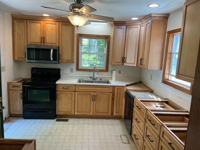 A kitchen with wooden cabinets and a black stove