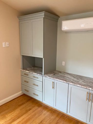 A kitchen with blue cabinets and a marble counter top.