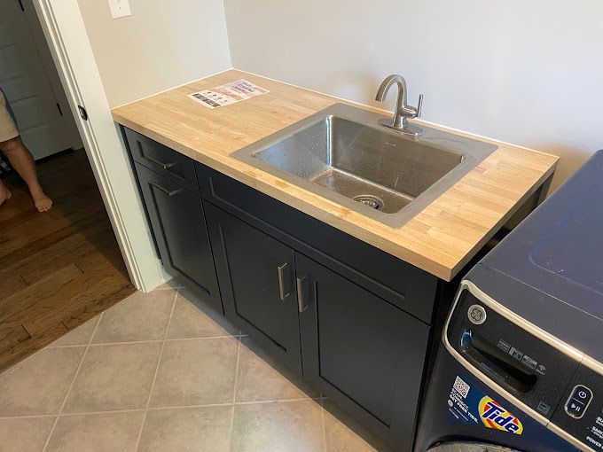 A laundry room with a sink , washer and dryer.