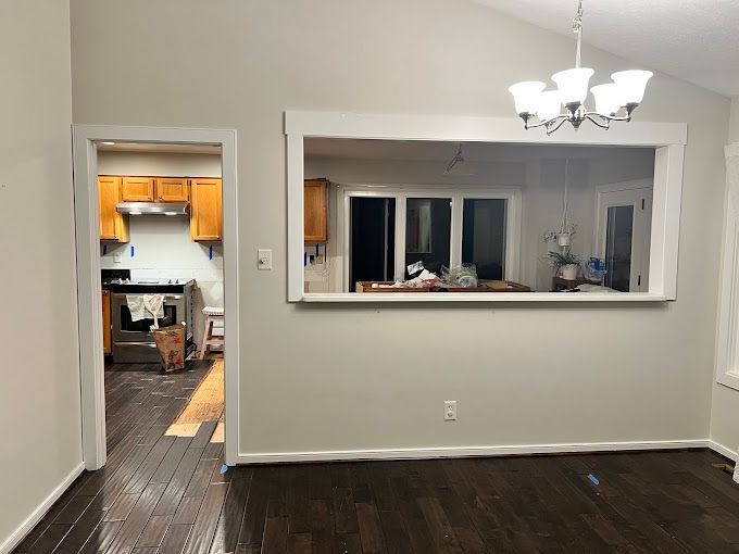 A kitchen and dining room are connected by a large window