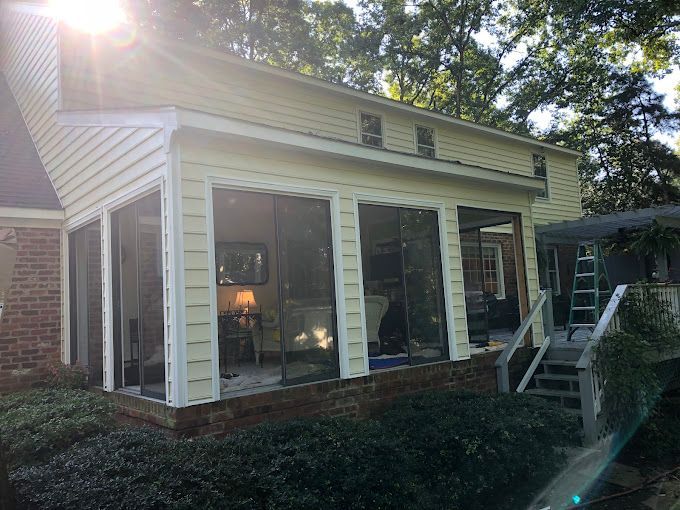 A screened in porch is being built on the side of a house.
