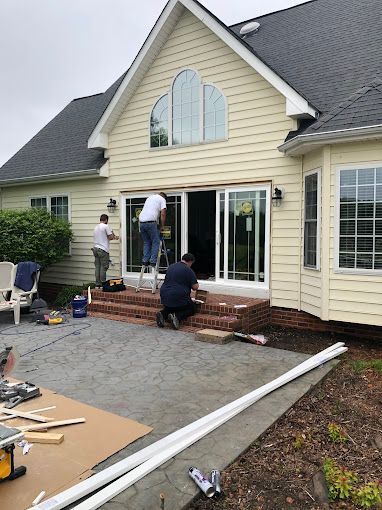 A group of men are working on the side of a house.