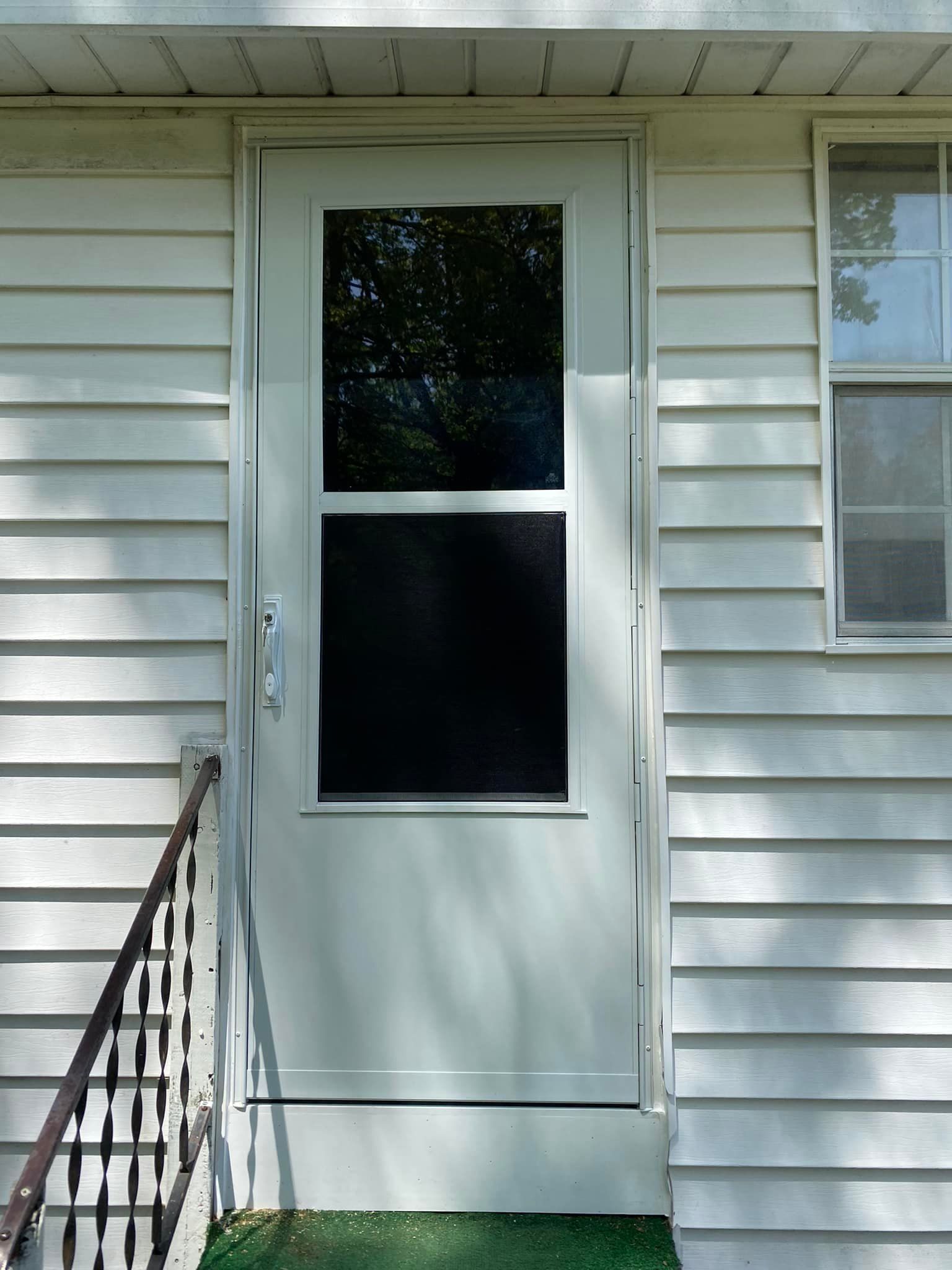 A white house with a screen door and a window