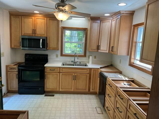A kitchen with wooden cabinets and a black stove