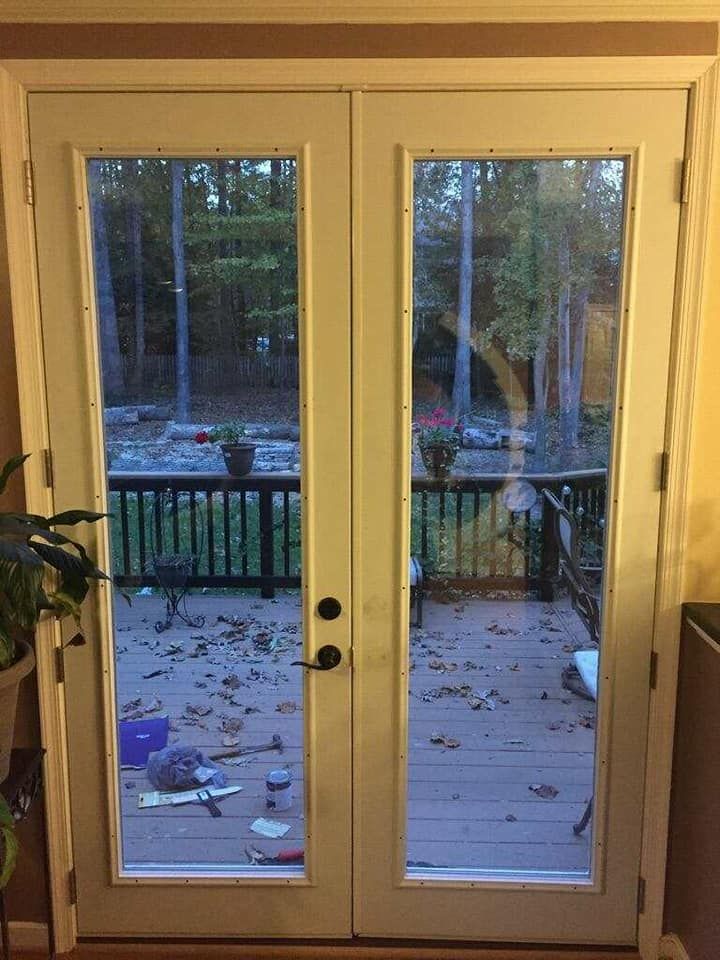 A patio door with a view of a deck and trees