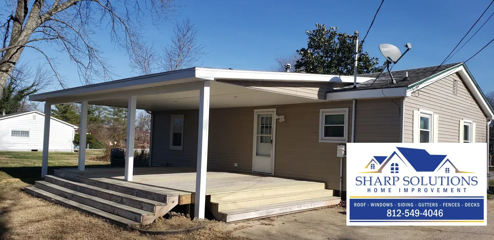 Small house with a covered porch and a SHARP Solutions sign in front, under a snowy roof