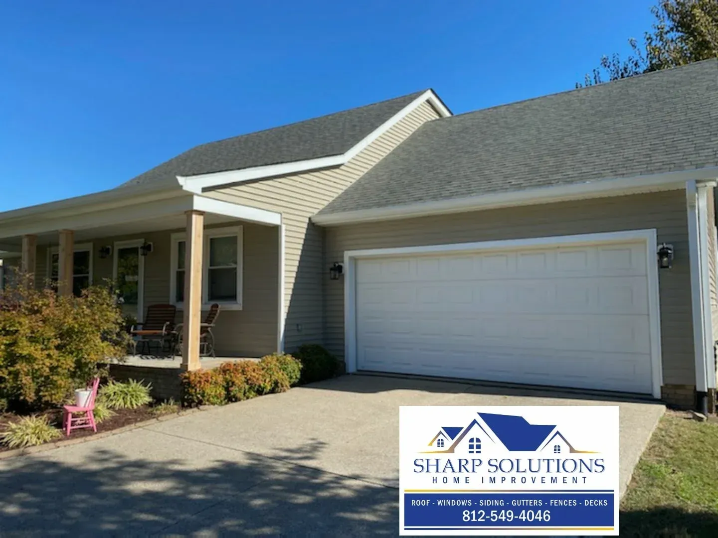 Single-story beige house with attached garage and front porch under a blue sky