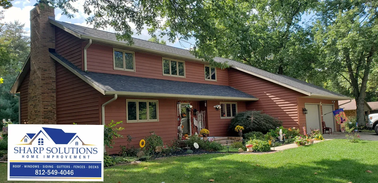 Red brick two-story house with a landscaped front yard and a Sharp Solutions logo in the lower left.