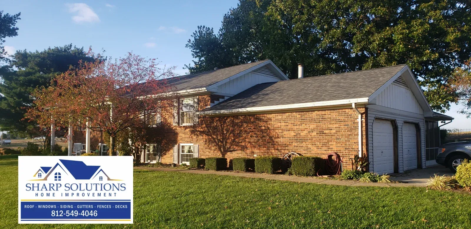 Brick office building with a sign reading “Staff Solutions” beside a green lawn and blue sky