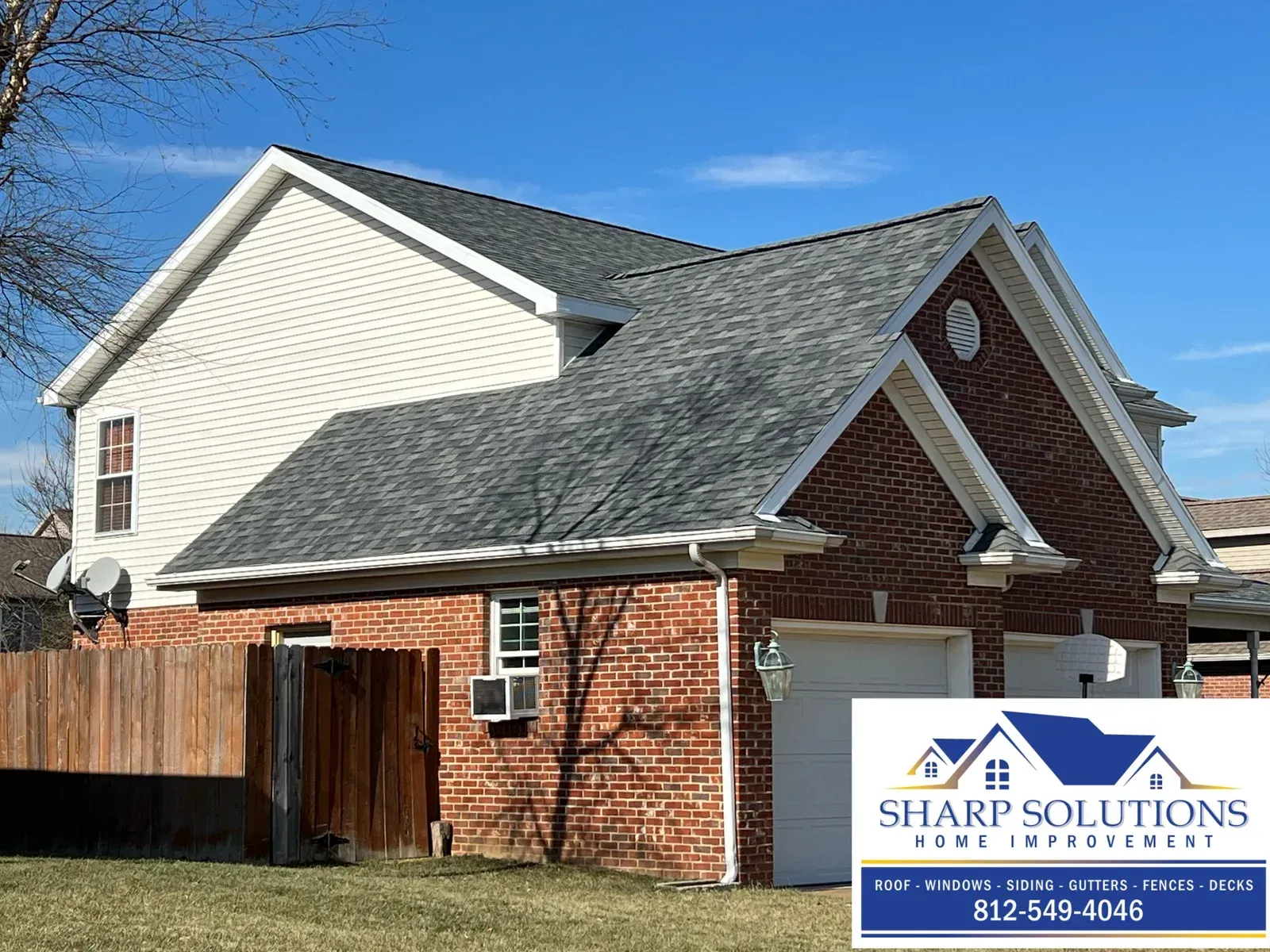 Suburban house roof and siding with Sharp Solutions roofing sign in front