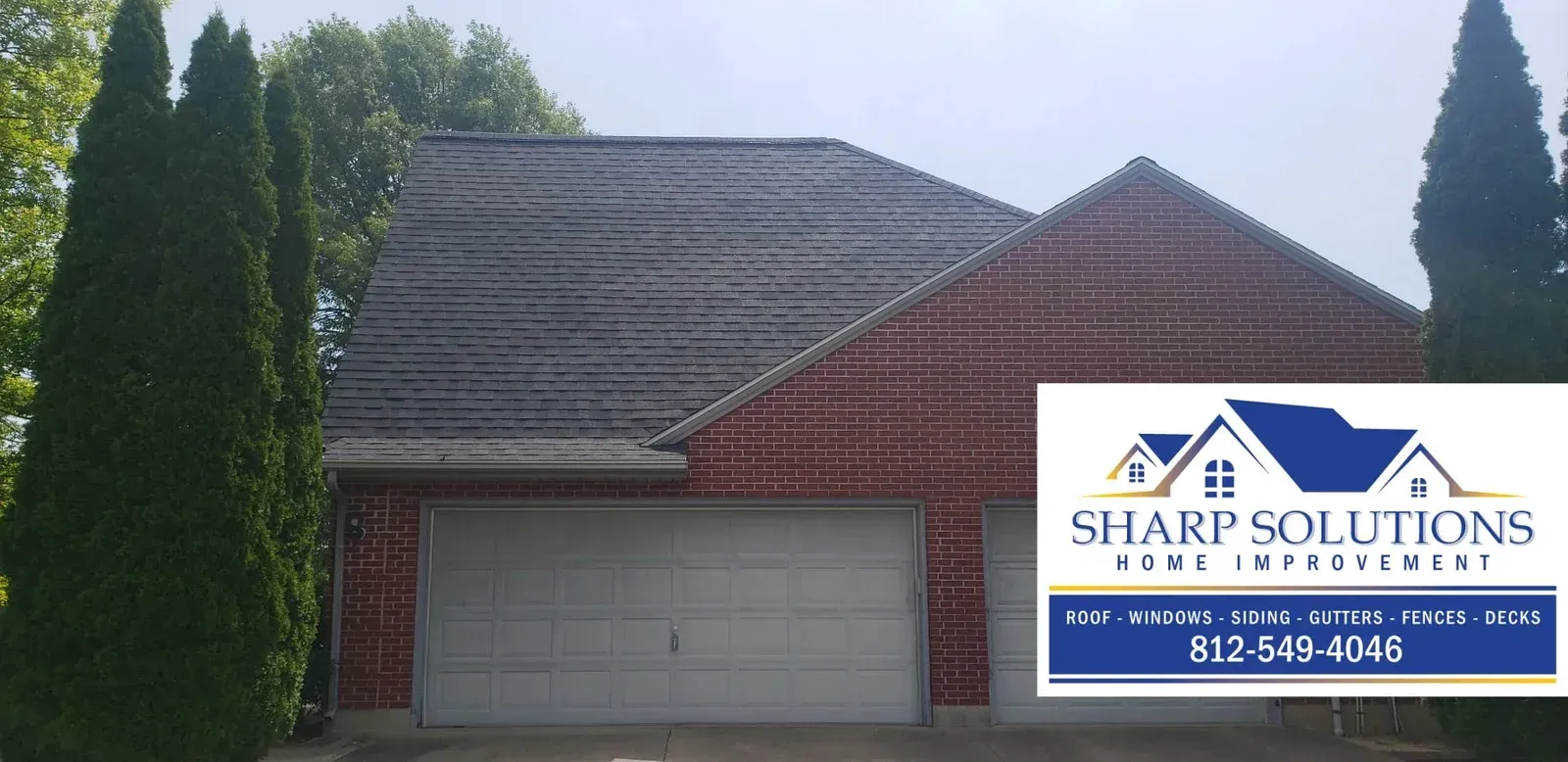 Suburban house with garage and a Sharp Solutions roofing sign in the front yard