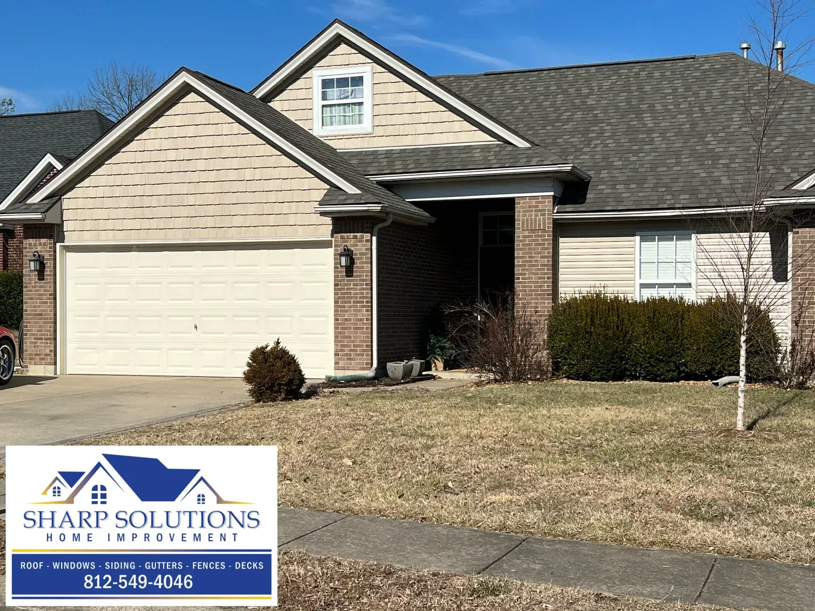 Suburban house with two-car garage and Sharp Solutions lawn sign in front yard