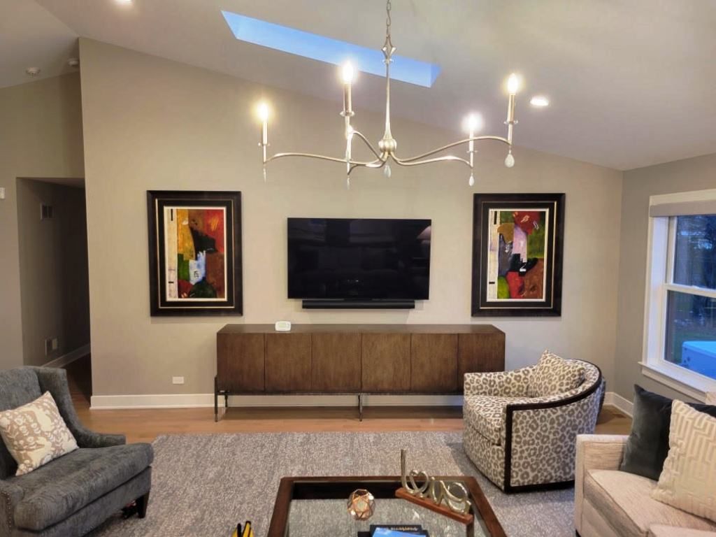 A living room with a couch, chair , table and television.