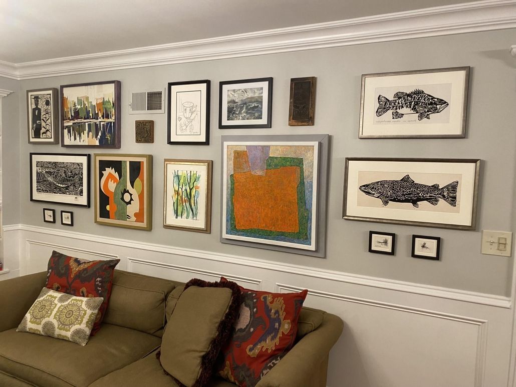 A living room with a couch and paintings on the wall