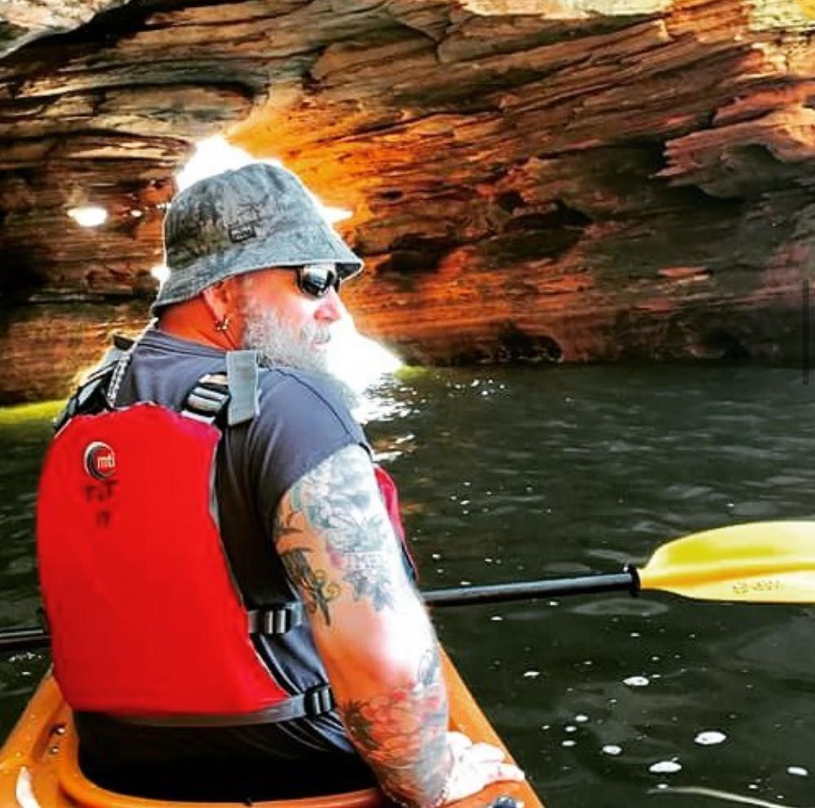 A brown and white dog is standing on its hind legs next to a door.