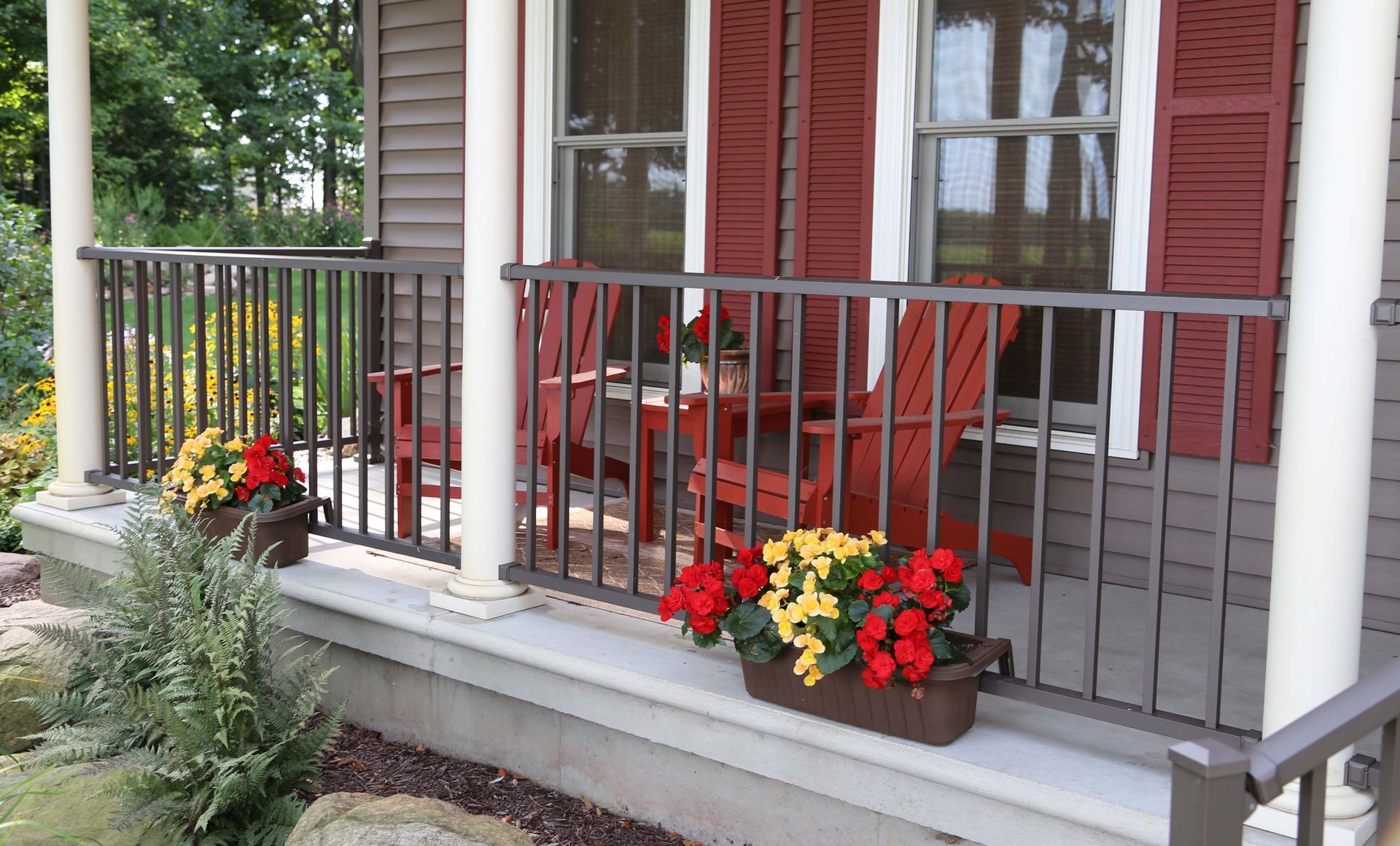 A porch with red chairs and flowers on it