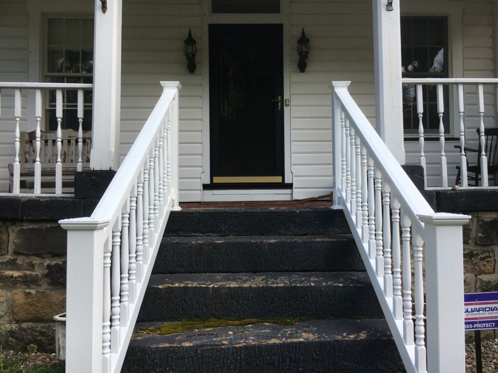 A white house with stairs leading up to the front door